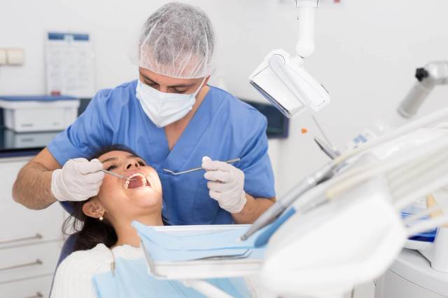 Dentiste examinant un patient lors d'une consultation dentaire pour traiter un mal de dents