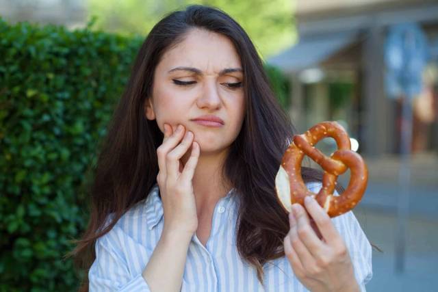 Femme souffrant d'une rage de dent se tenant la joue en douleur dentaire