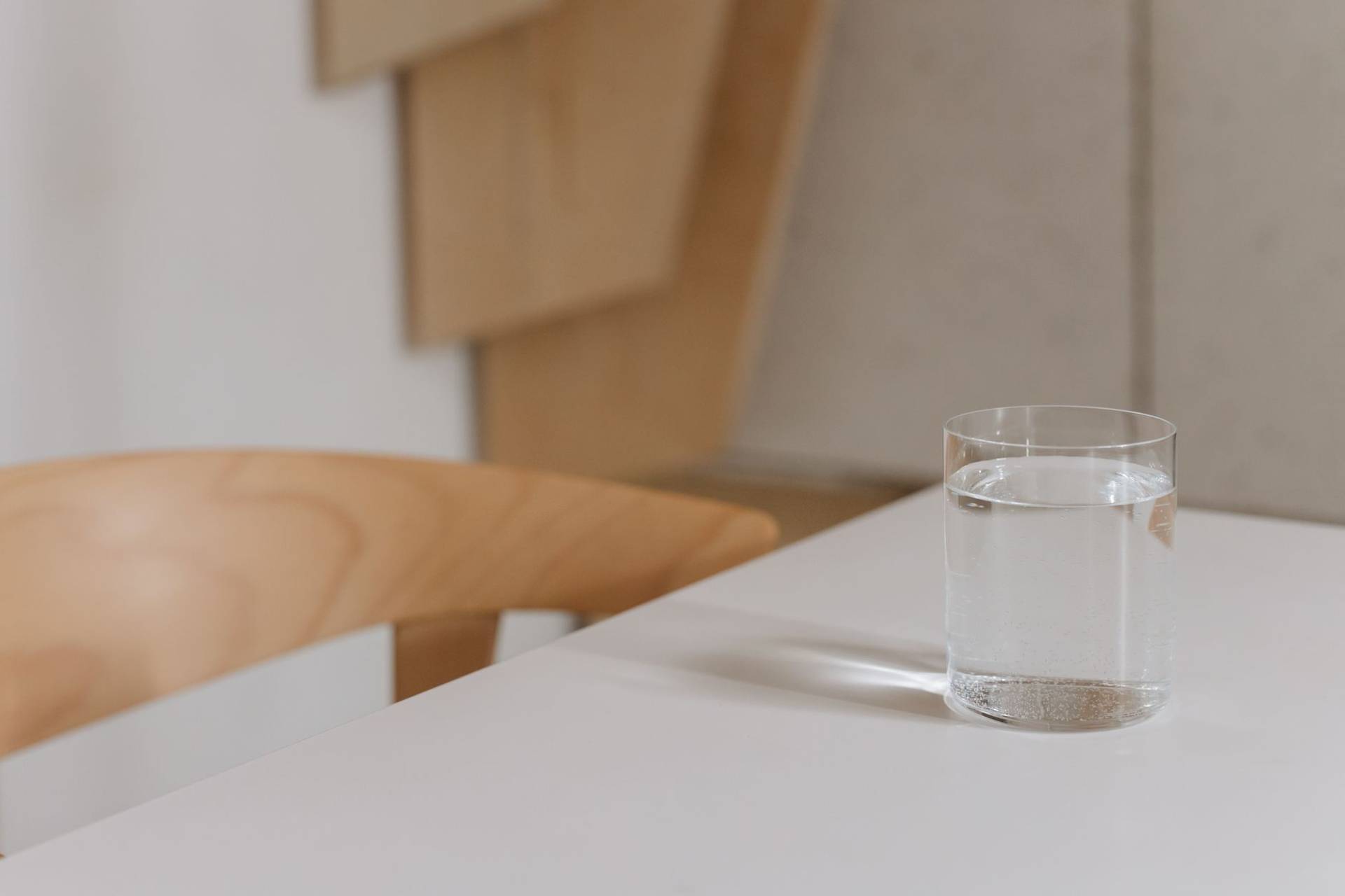 Verre d’eau posé sur une table.