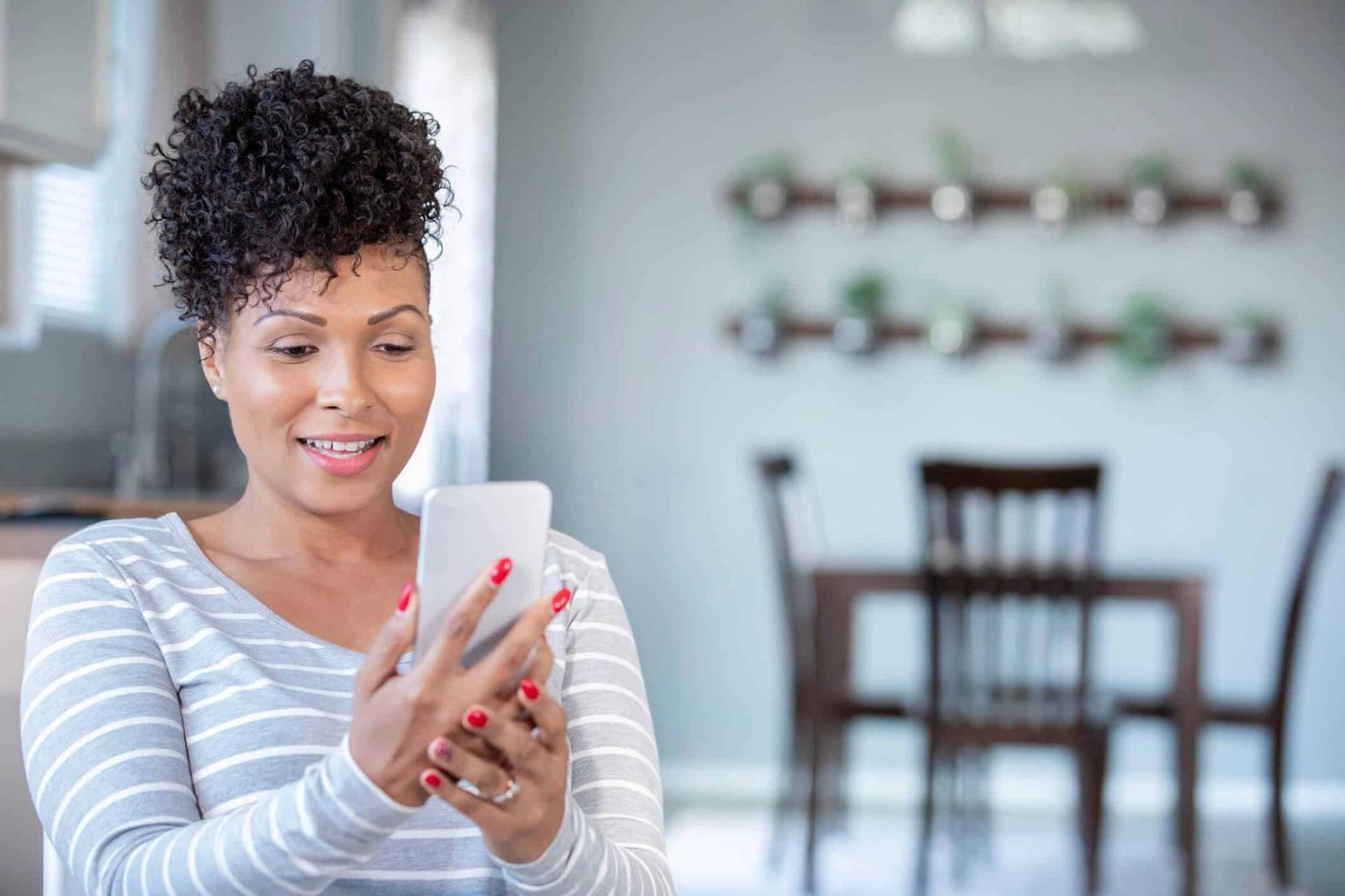 Femme souriante regardant son téléphone.