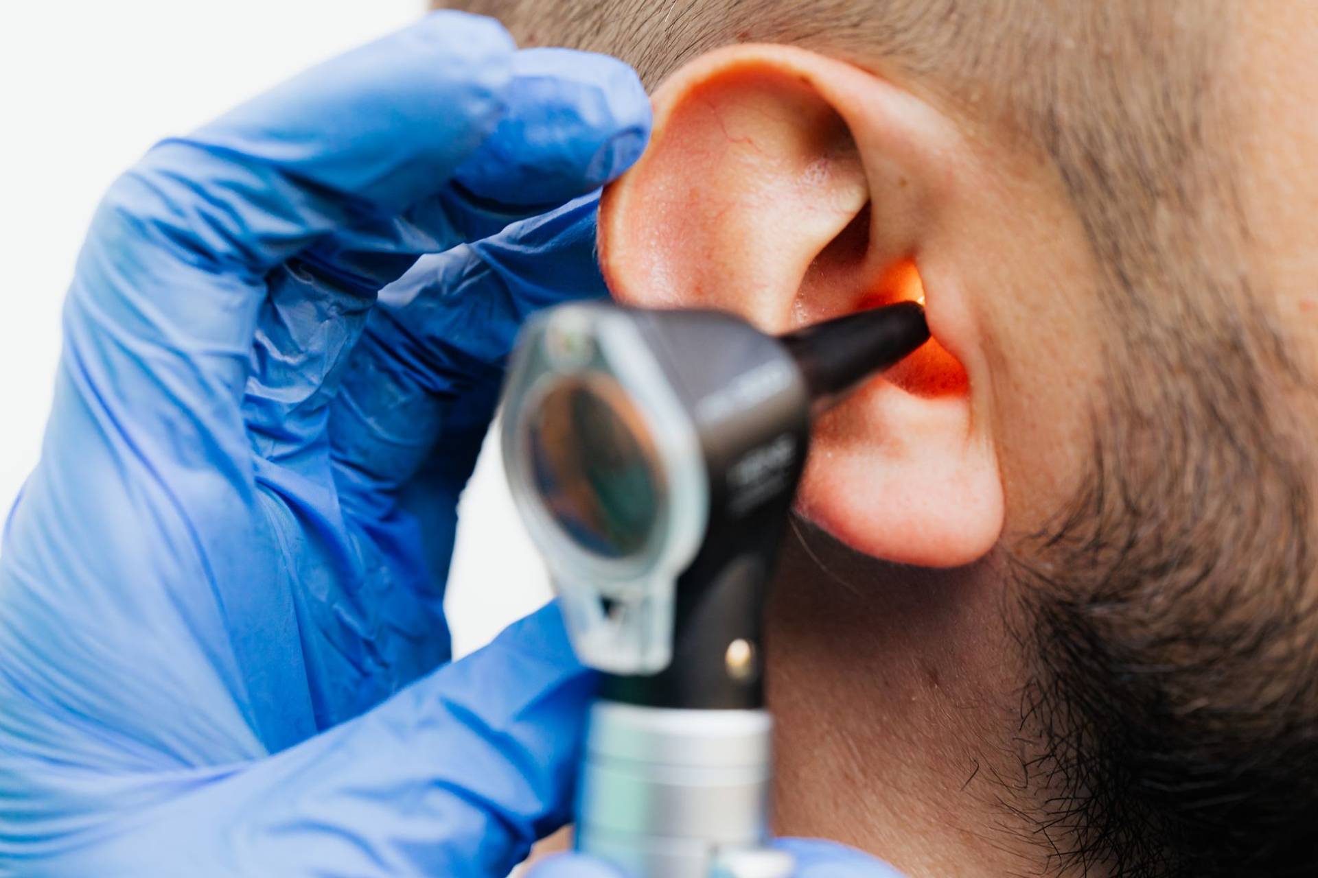 Examen d’une oreille avec un otoscope, en gros plan.