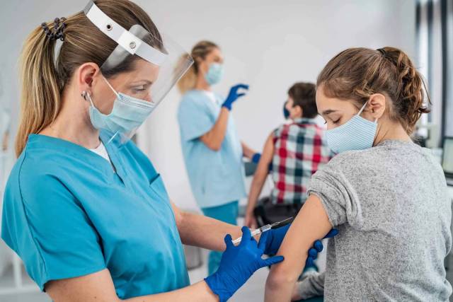Enfant recevant une injection de vaccin COVID-19 par un professionnel de santé