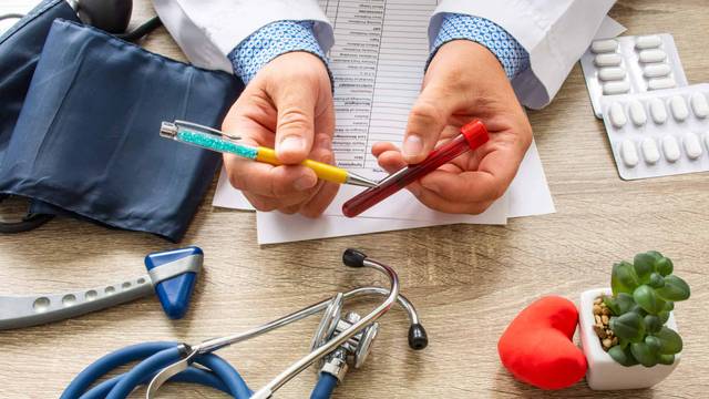 Mains présentant des tubes de prélèvement sanguin au-dessus de matériel médical.