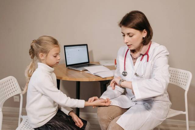 Un médecin examine une jeune fille lors d'une consultation pédiatrique dans un cadre clinique intérieur