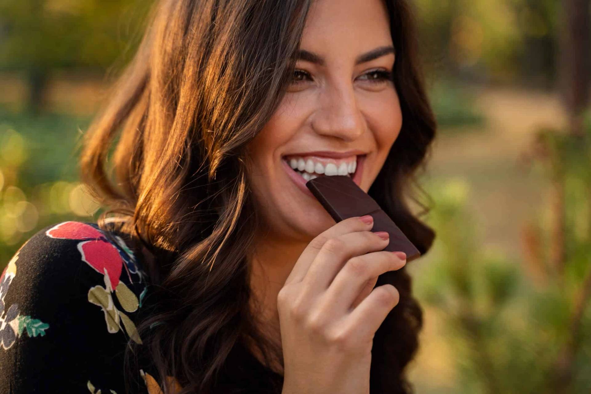 Femme mangeant un carré de chocolat.