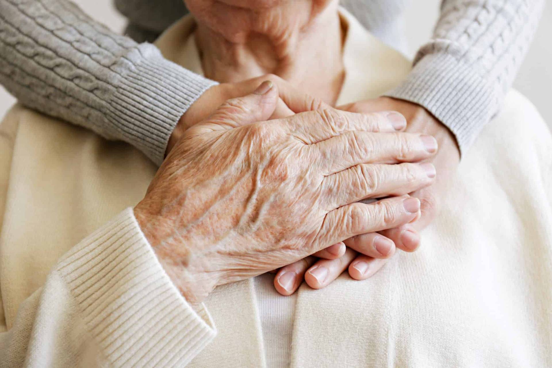 Deux personnes unissent leurs mains dans un geste de soutien.