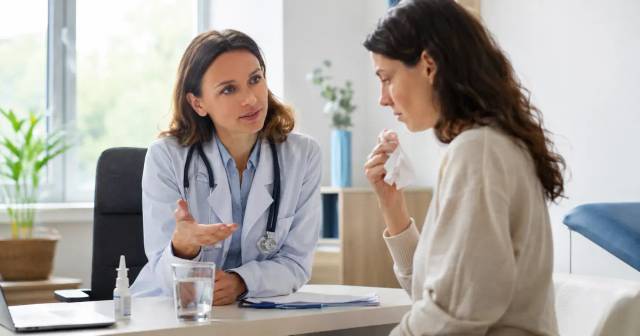 Médecin en consultation avec un patient enrhumé dans un cabinet médical français pour soigner un rhume