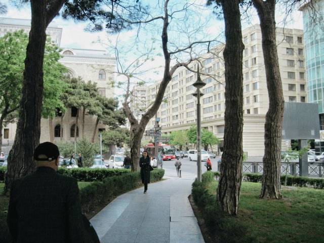 Vue d'une rue de la ville avec des passants, de grands arbres et une architecture urbaine