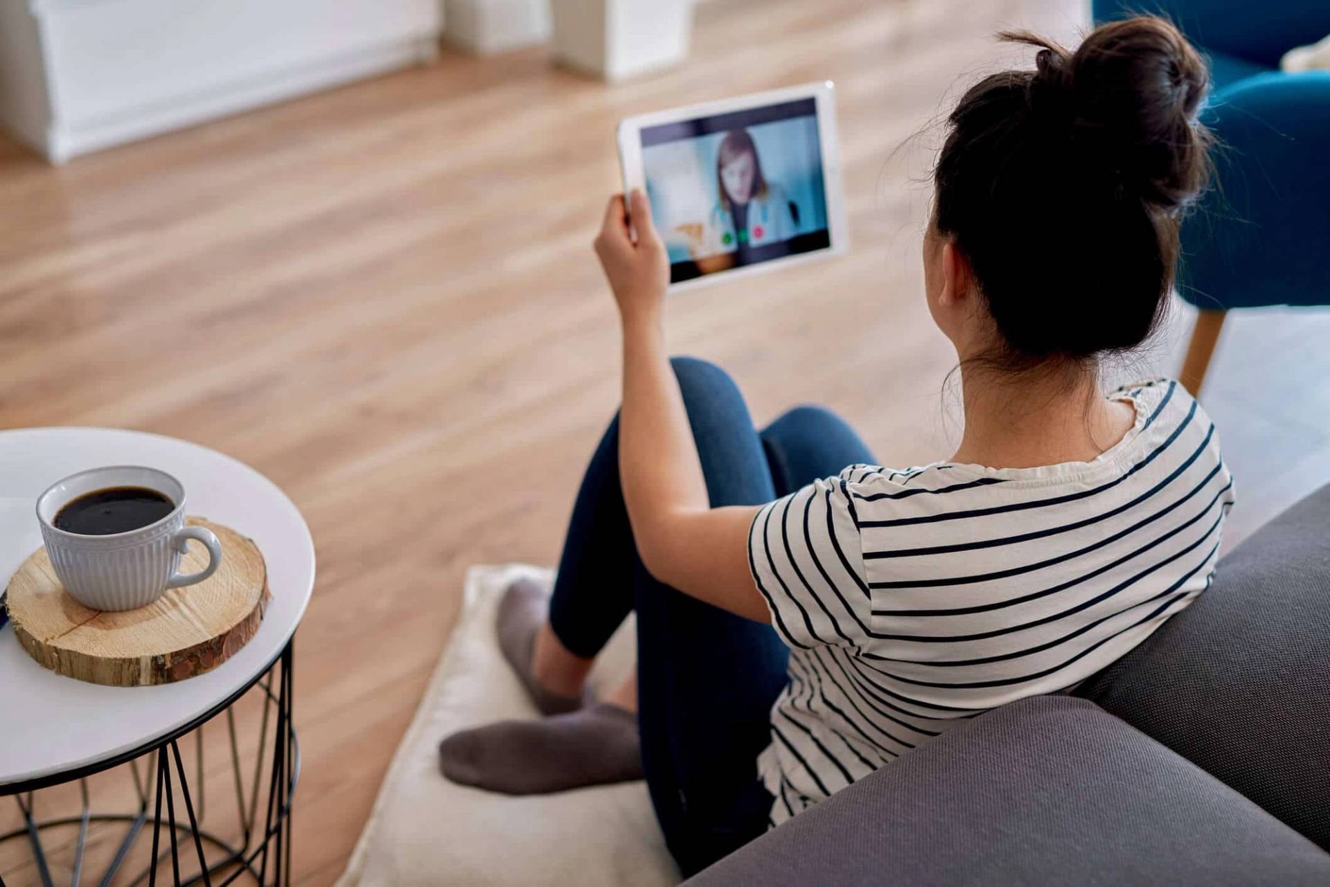 Personne échangeant en visioconférence sur une tablette.