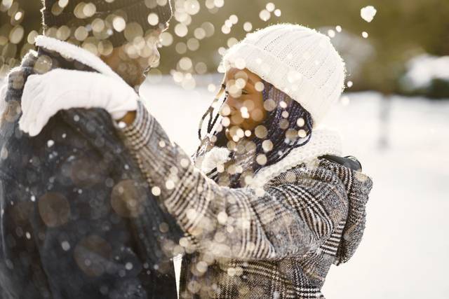 Couple profitant d'un moment romantique dans la neige, partageant la chaleur d'une étreinte amoureuse