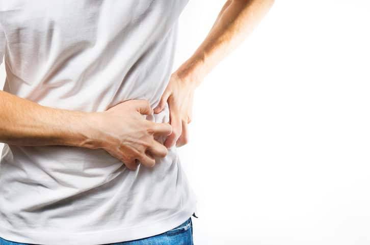 Personne tenant le côté de son abdomen.
