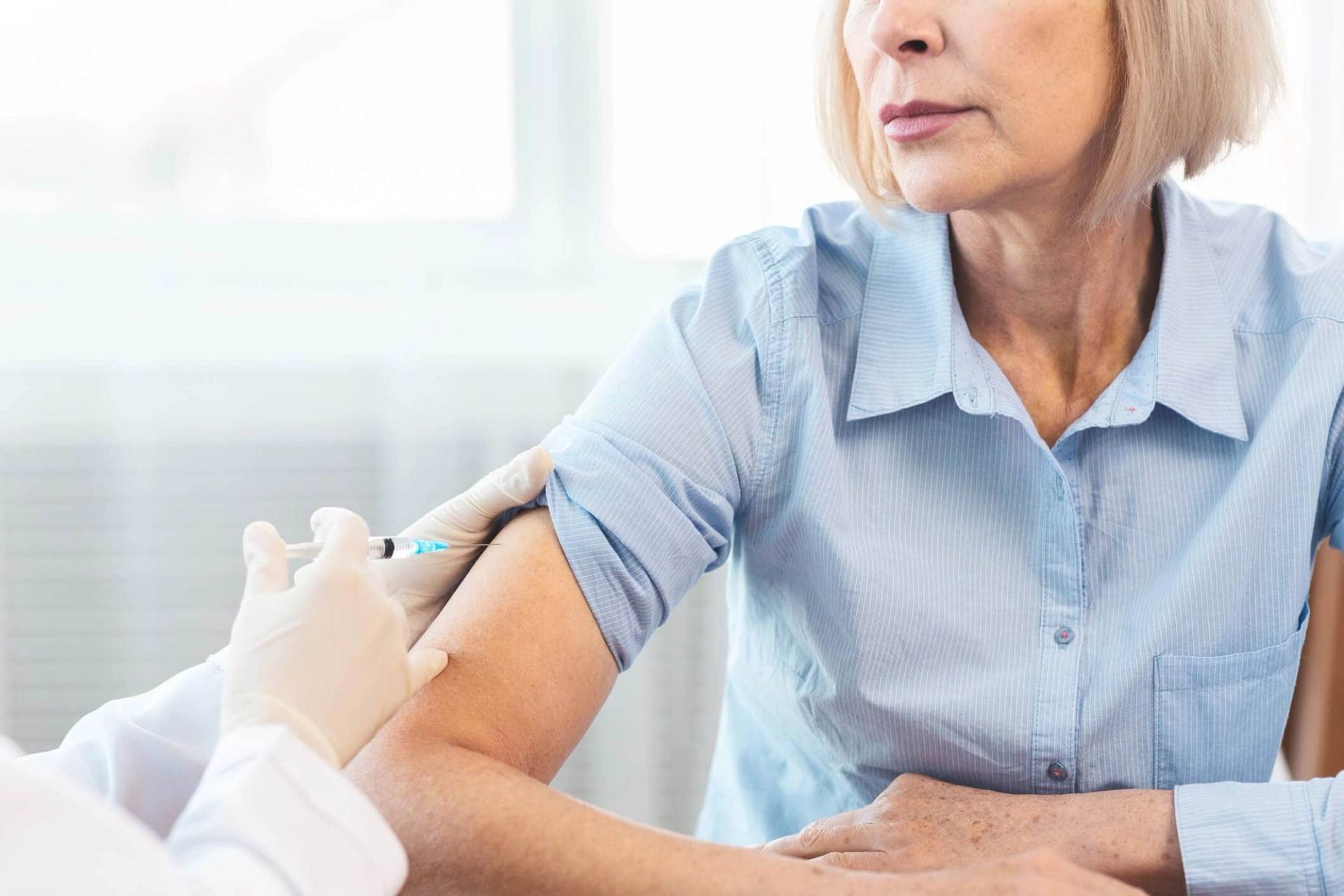 Professionnel faisant une injection dans le bras d’une femme.