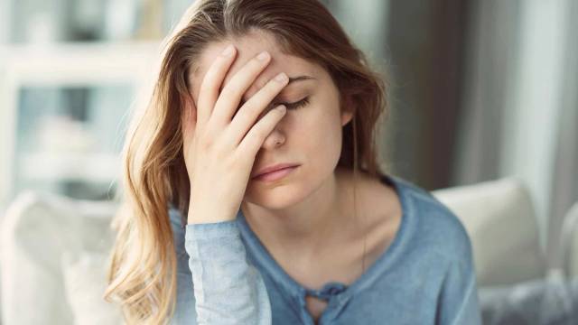 Femme souffrant de migraine se tenant la tête lors d'une consultation médicale