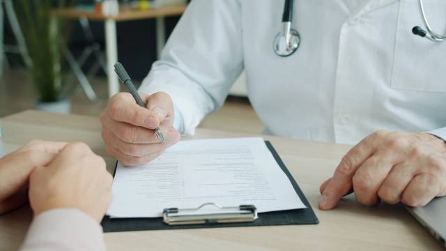 Médecin et patient remplissant un document lors d’une consultation