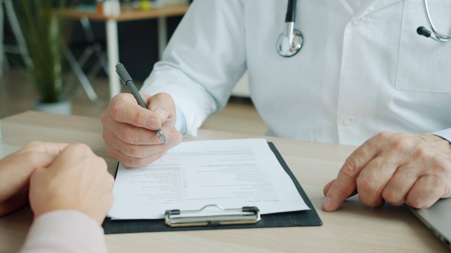 Médecin et patient remplissant un document lors d’une consultation