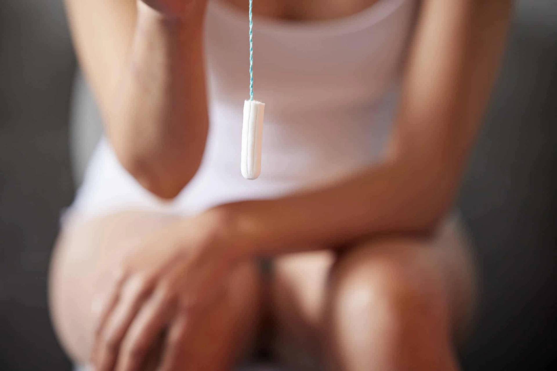 Femme tenant un tampon hygiénique.