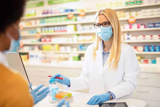 Remise d’un produit au comptoir d’une pharmacie.