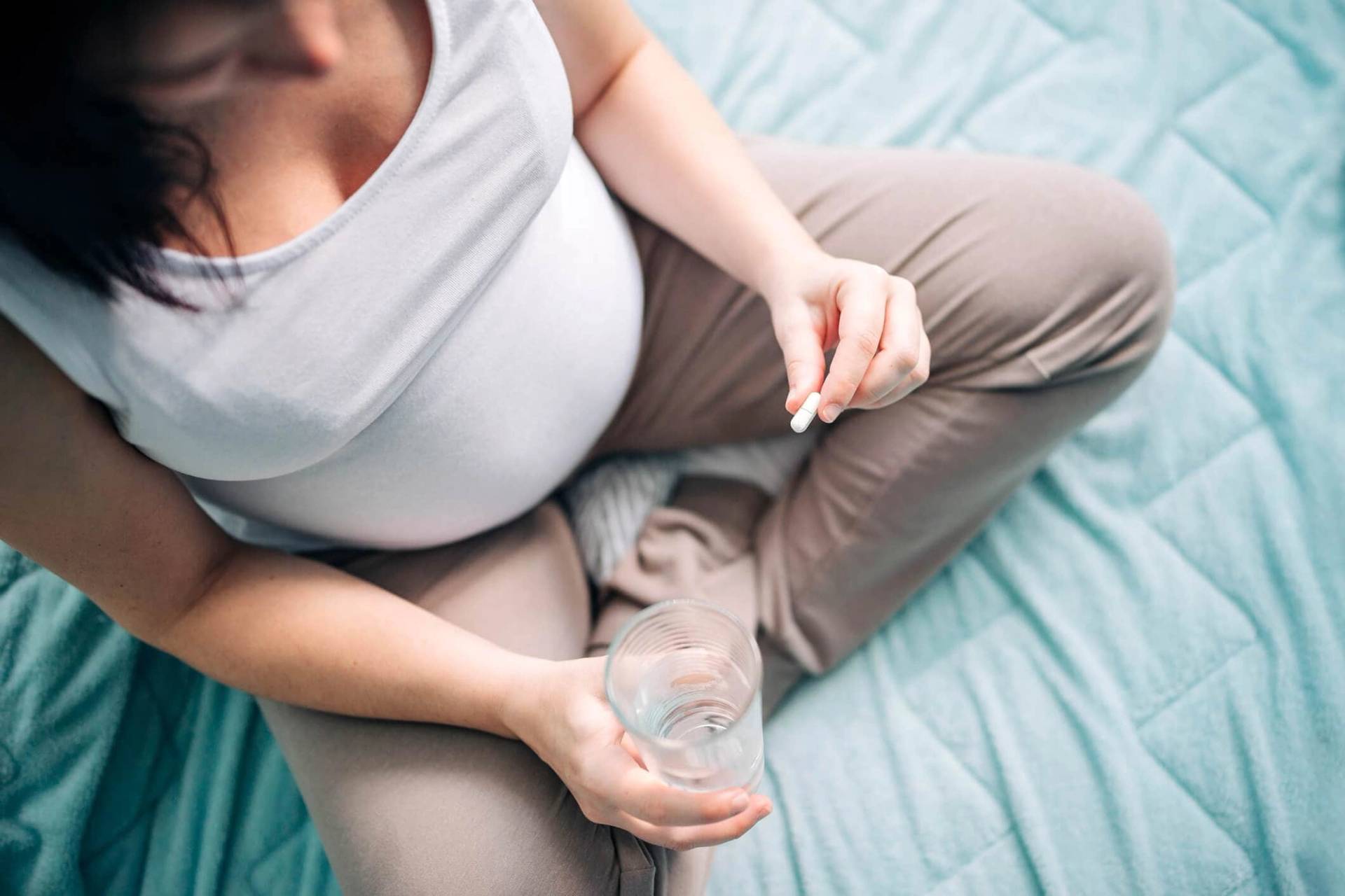 Personne enceinte tenant un verre d’eau.