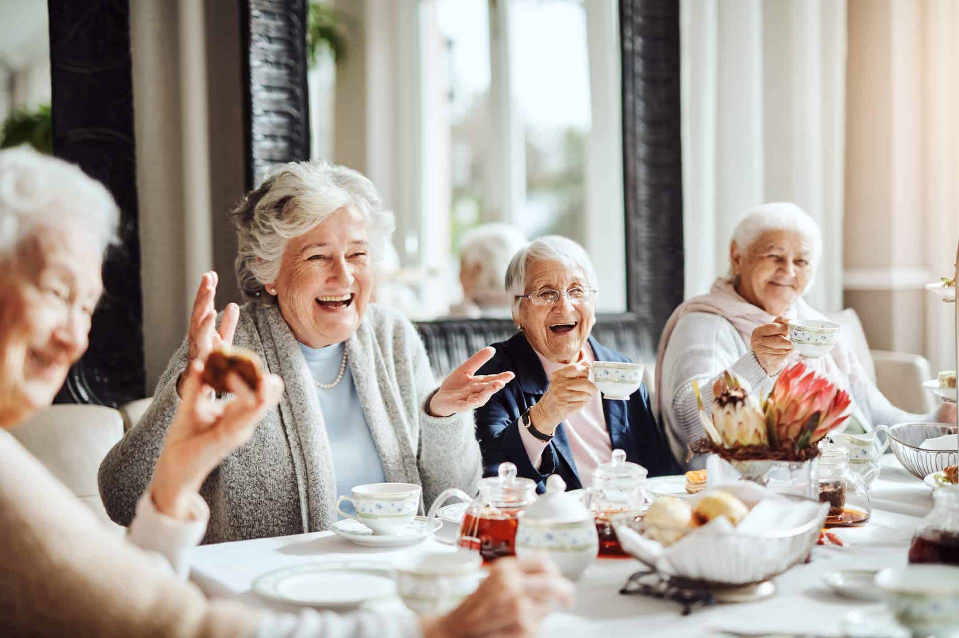 Femmes âgées partageant un repas à table.