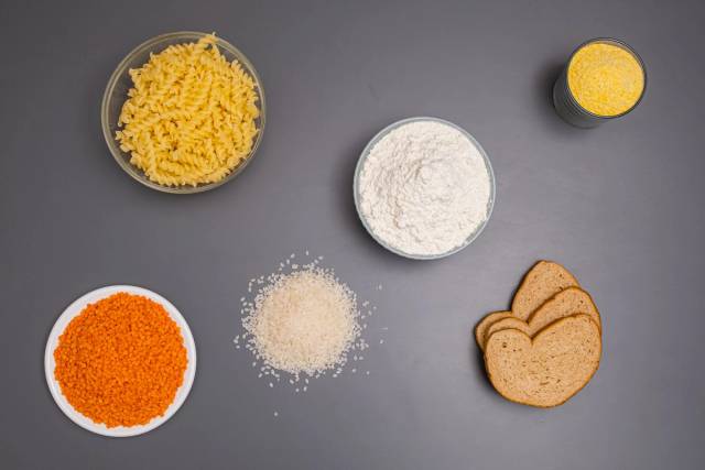 Pâtes, riz, farine, lentilles et autres ingrédients secs disposés dans des bols.