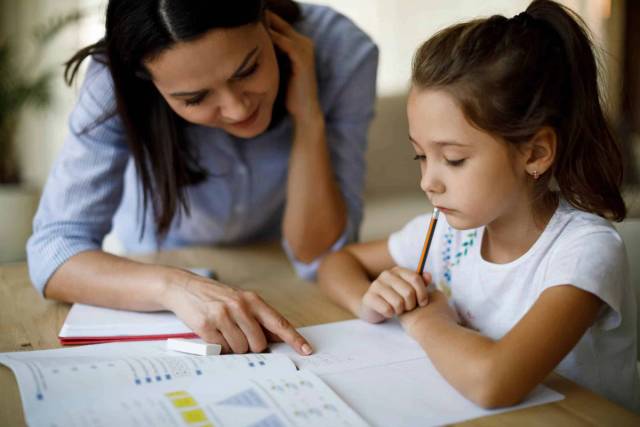Mère de famille apprenant à sa fille à lire.
