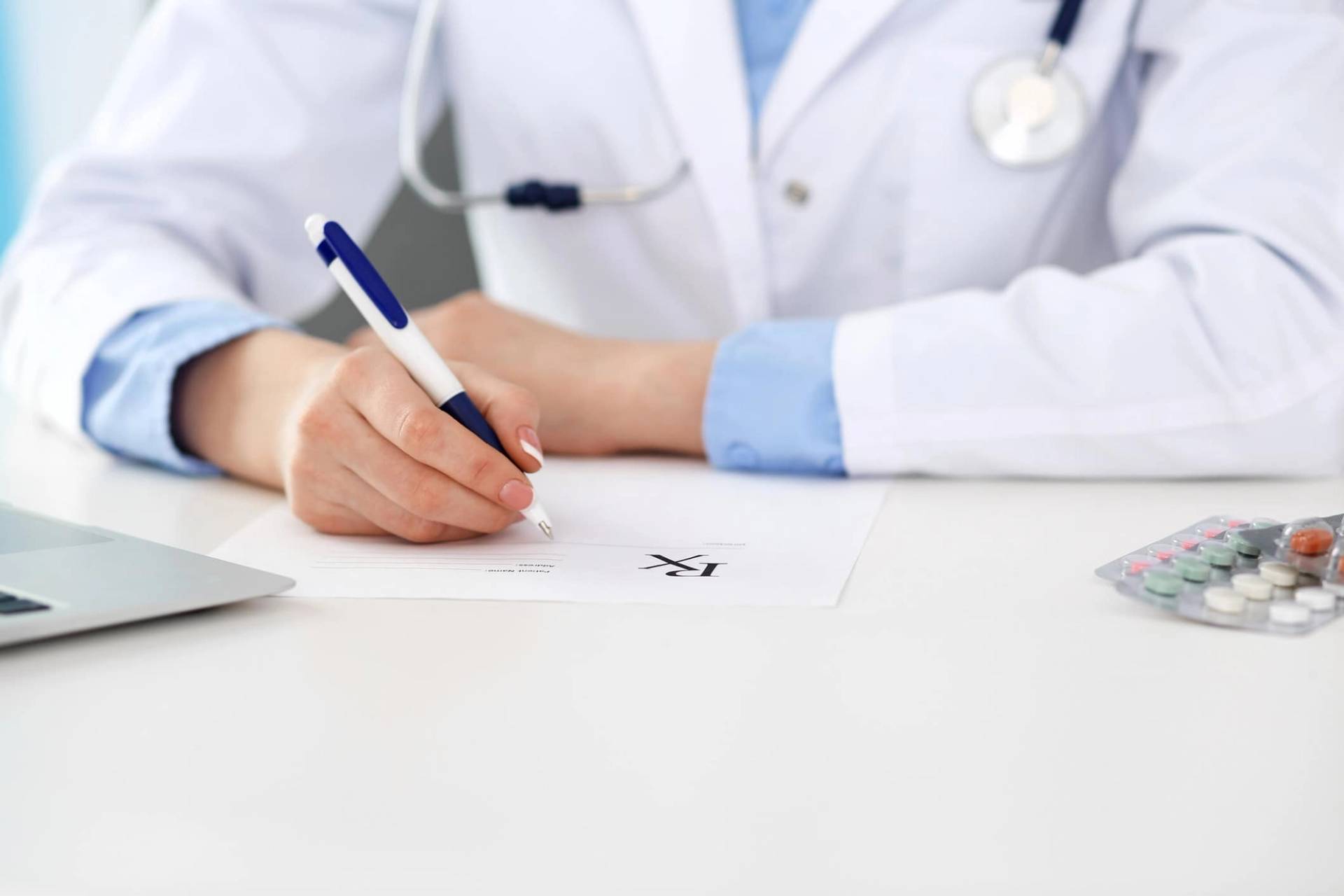 Médecin qui rédige un certificat médical sur son bureau