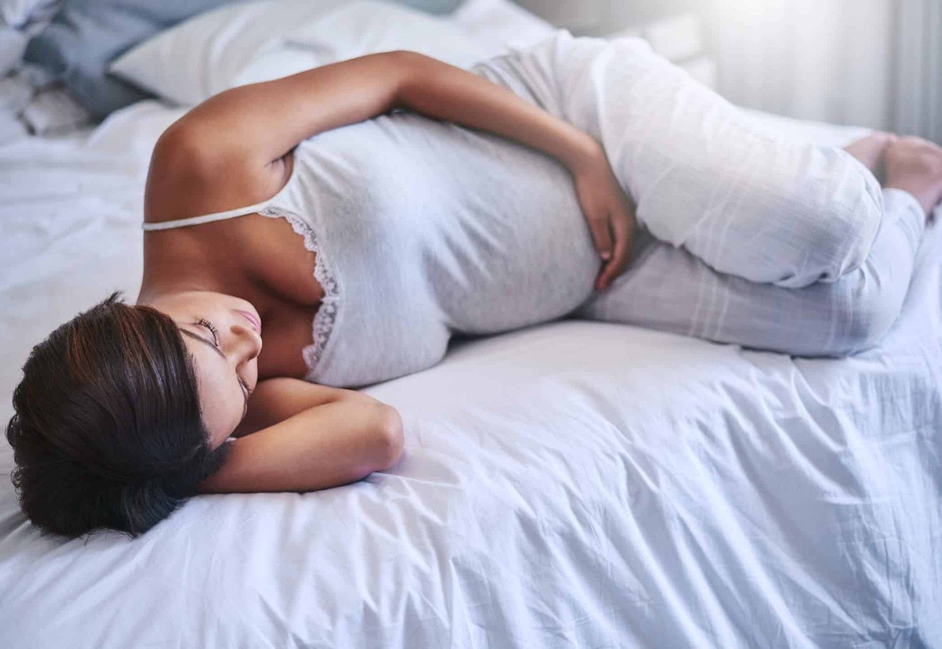Femme enceinte allongée sur un lit.