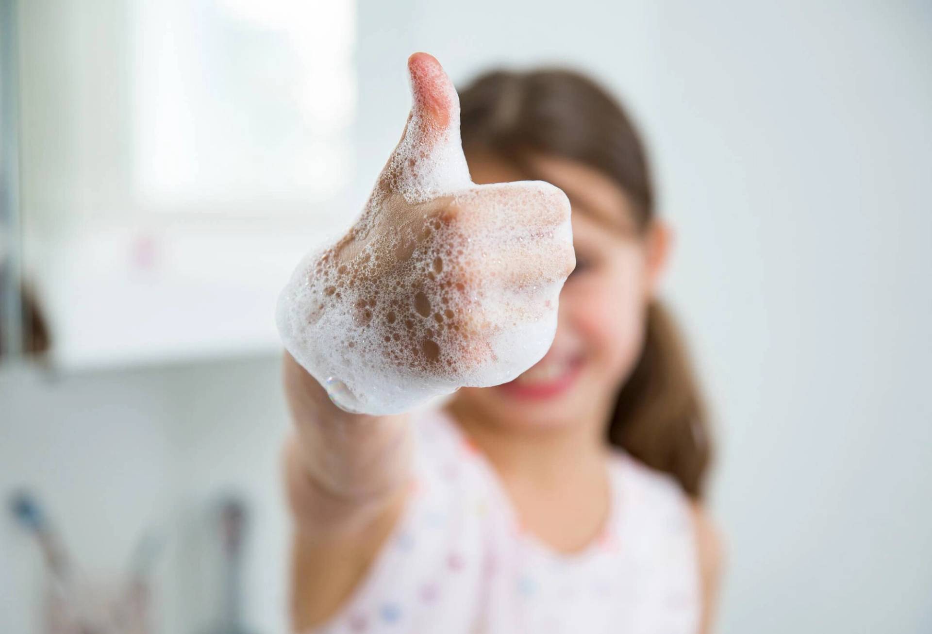 Enfant avec du savon sur les mains.
