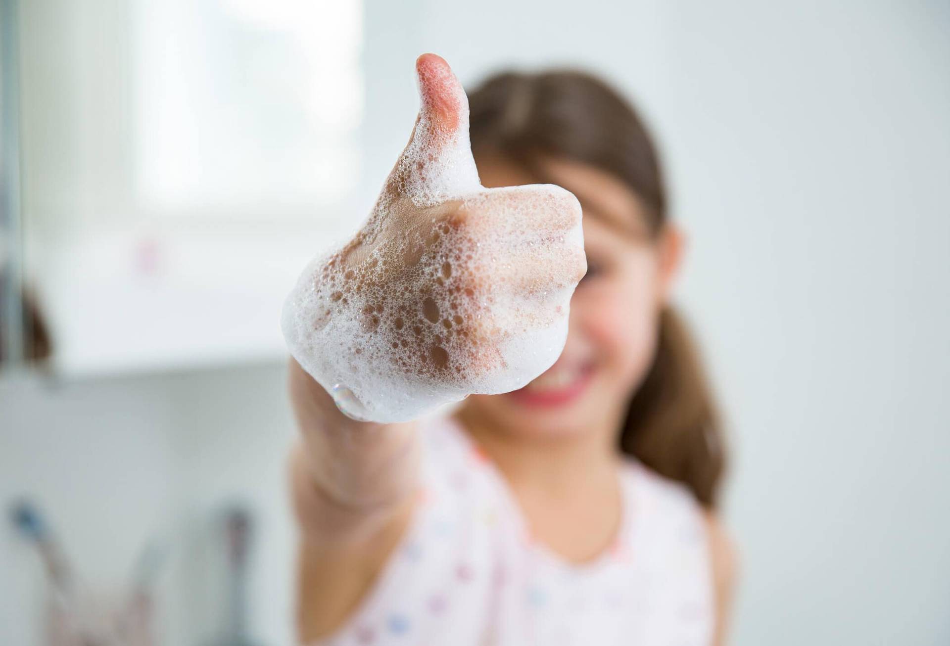 Enfant avec du savon sur les mains.