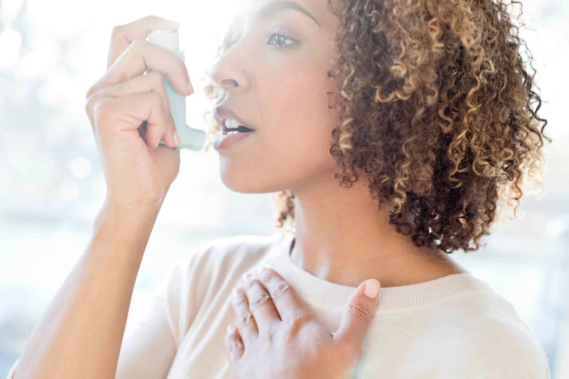 Femme utilisant un inhalateur.