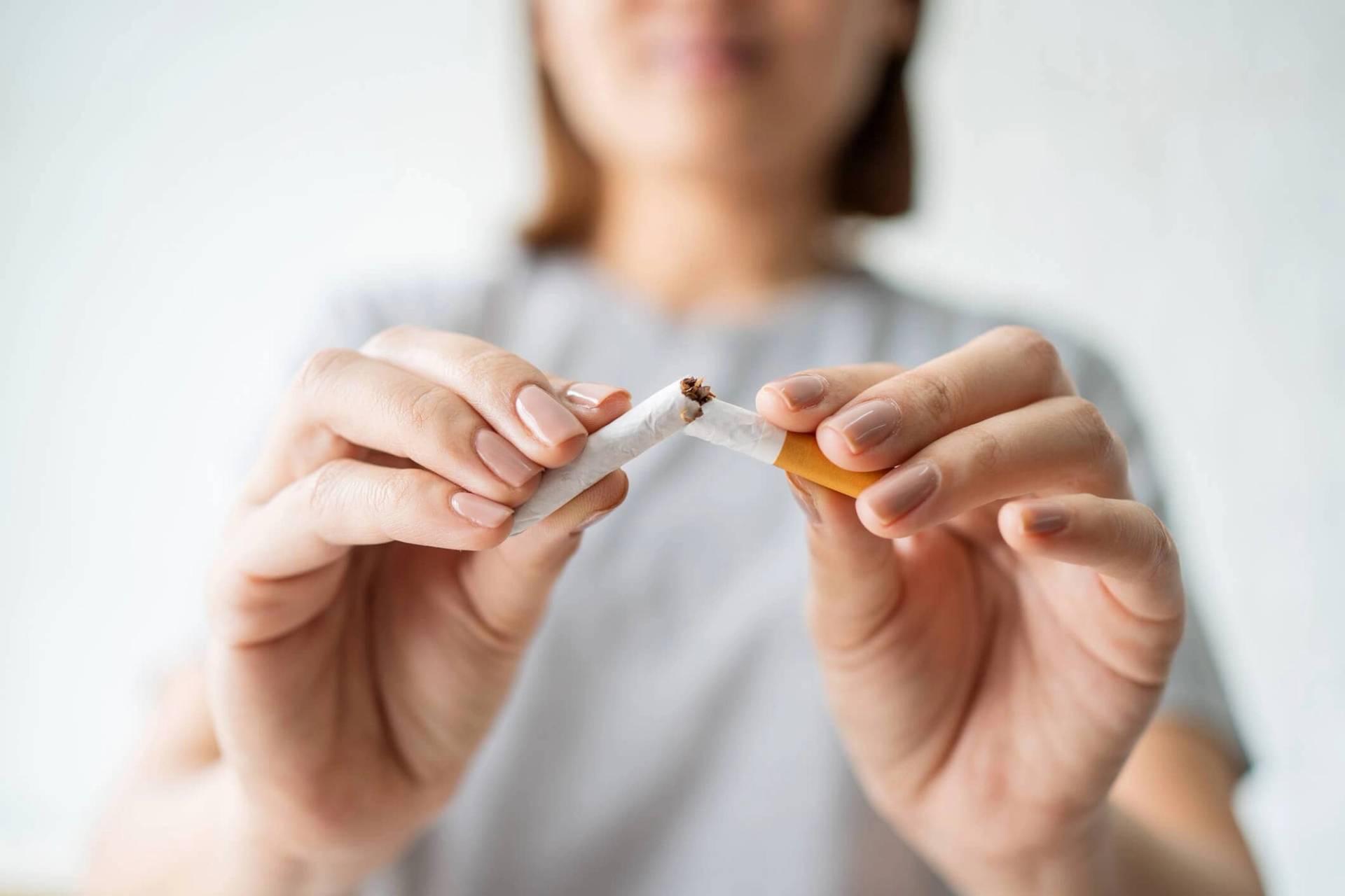 Personne brisant une cigarette entre ses doigts.