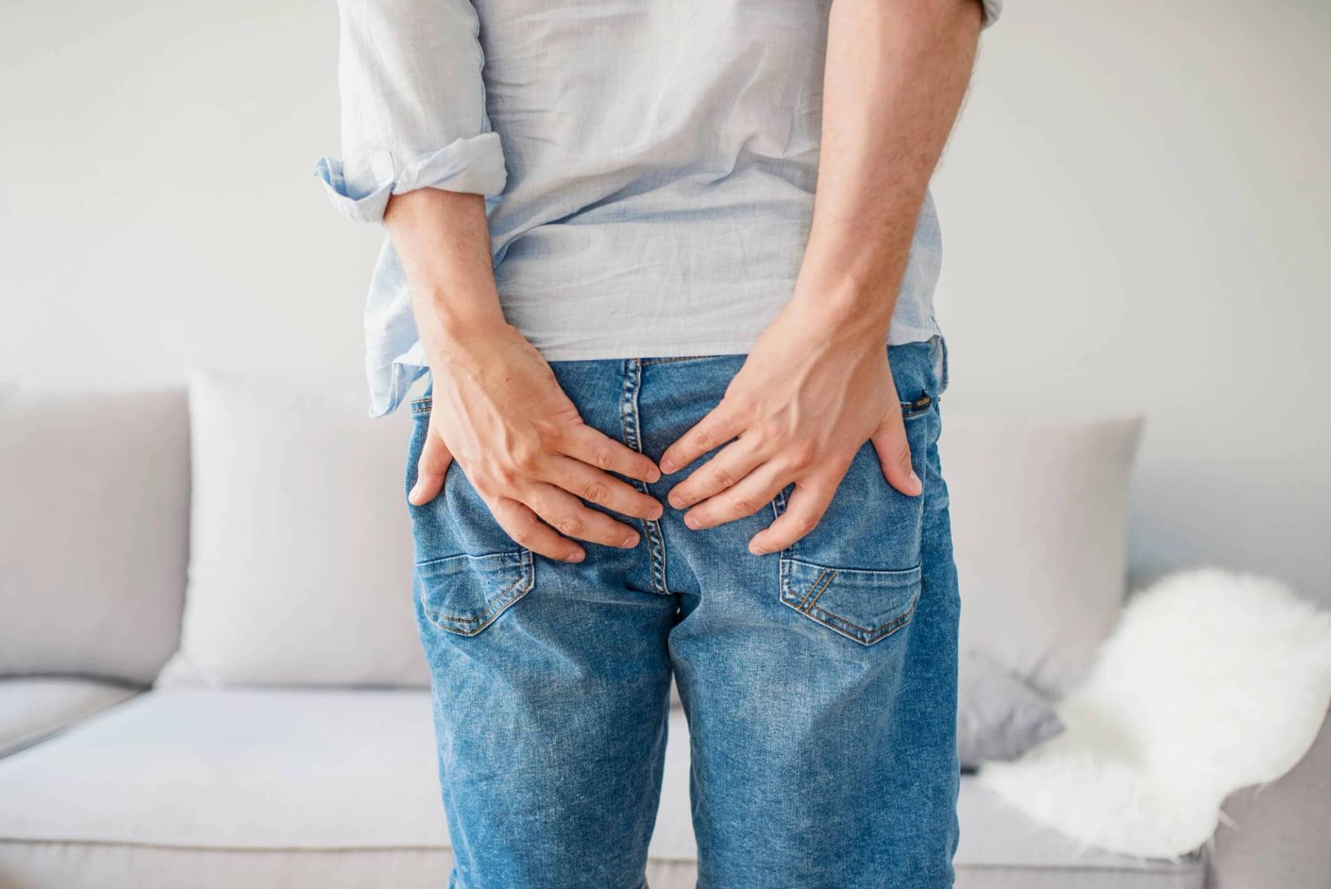 Personne de dos posant ses mains sur les fesses.
