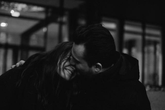 Portrait intime en noir et blanc d'un couple partageant un moment de tendresse à l'intérieur