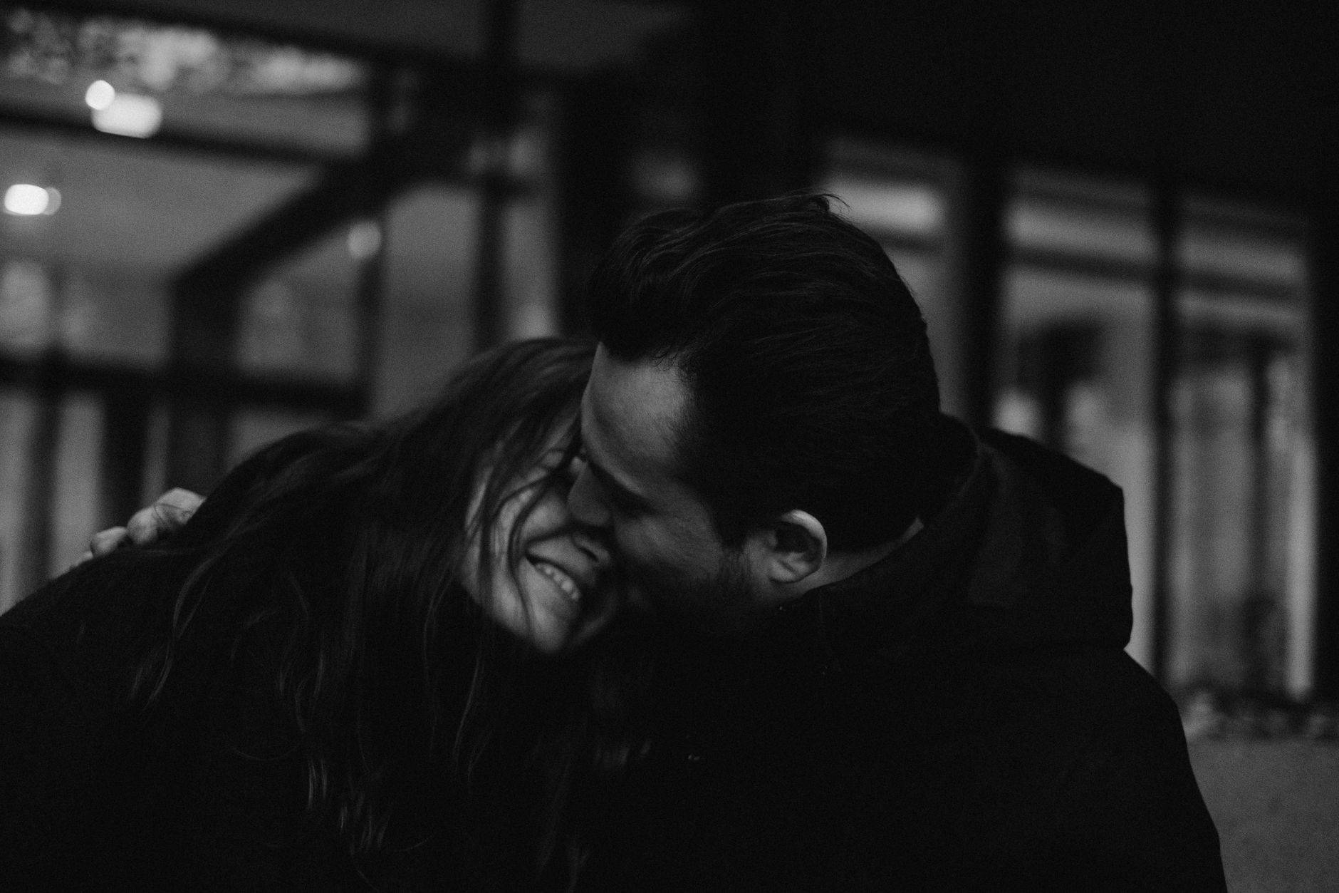 Portrait intime en noir et blanc d'un couple partageant un moment de tendresse à l'intérieur