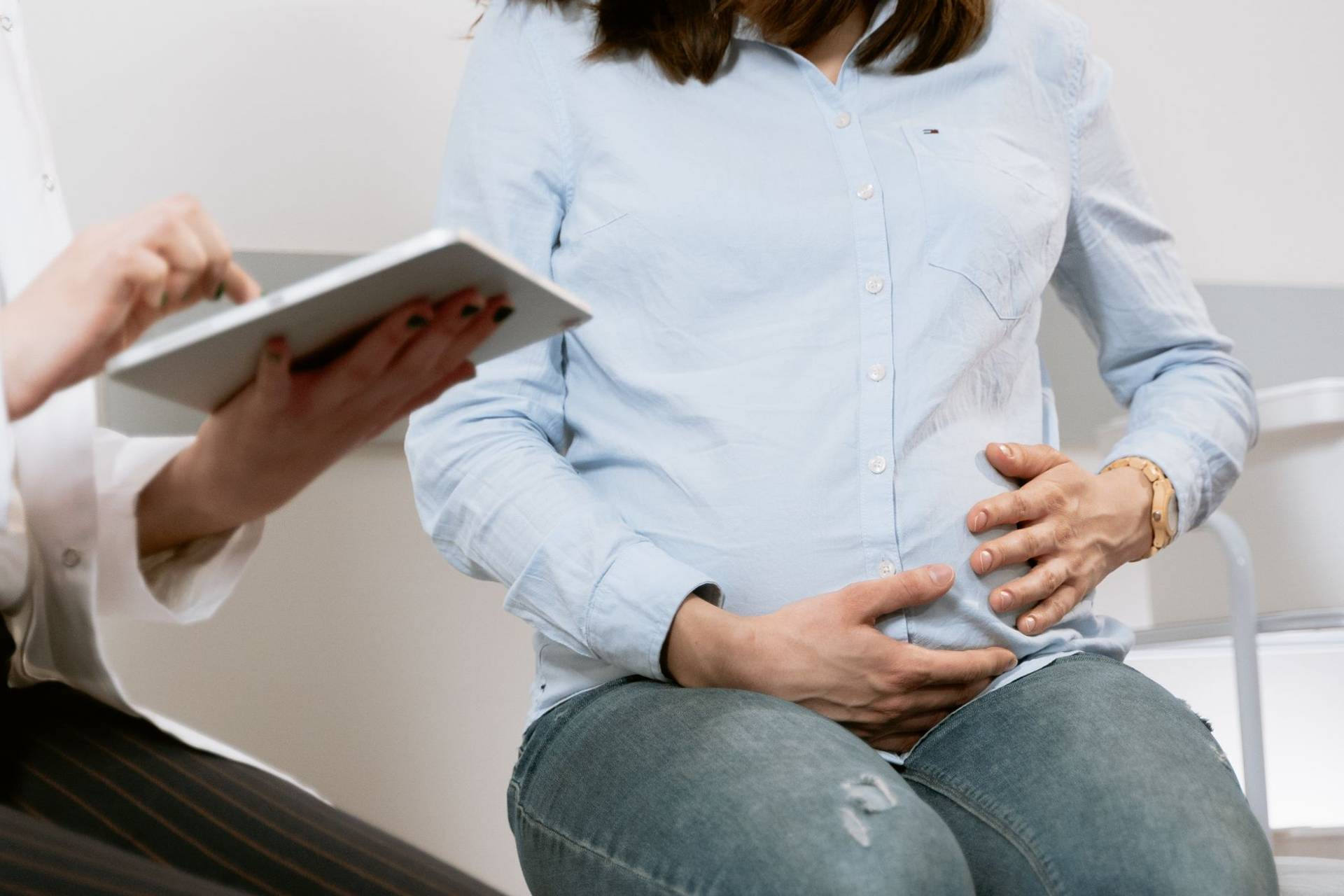 Femme enceinte assistant à une consultation médicale, illustrant l'interaction entre le médecin et le patient