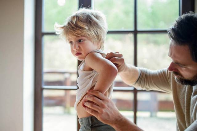 Examen médical d'une éruption cutanée chez un enfant par un professionnel de santé