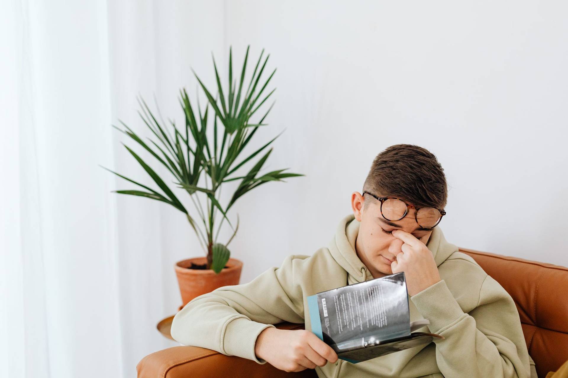 Jeune homme épuisé se frottant les yeux : la fatigue de la mononucléose peut durer des mois