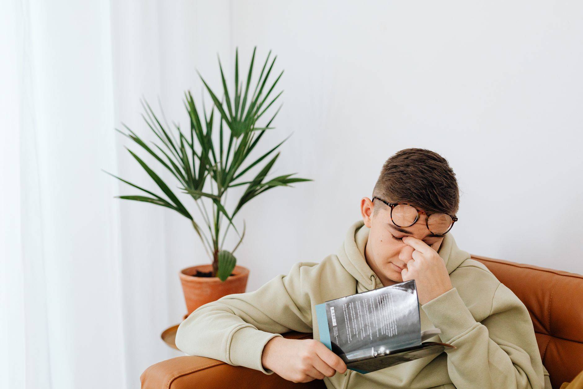 Jeune homme épuisé se frottant les yeux : la fatigue de la mononucléose peut durer des mois