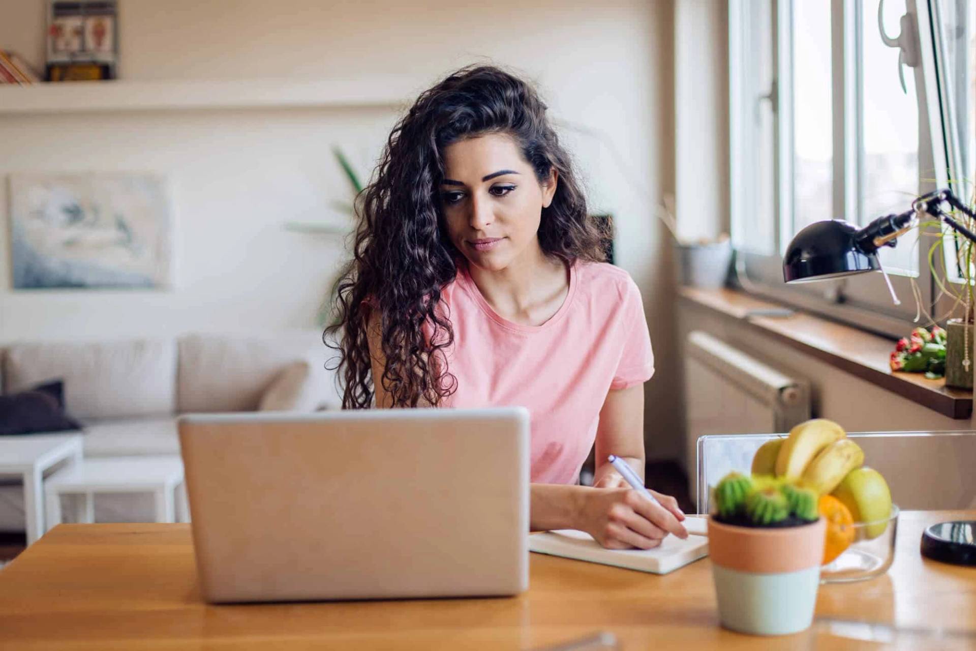 Femme assise à une table devant un ordinateur portable.