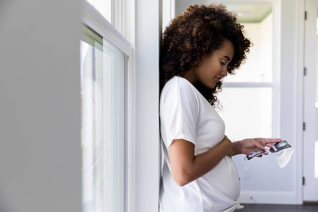 Une femme enceinte regarde une image d'échographie.