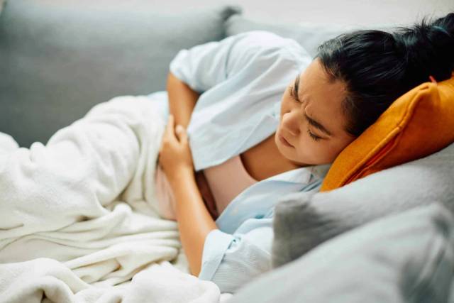 Femme souffrant de douleurs abdominales lors d'une intoxication alimentaire