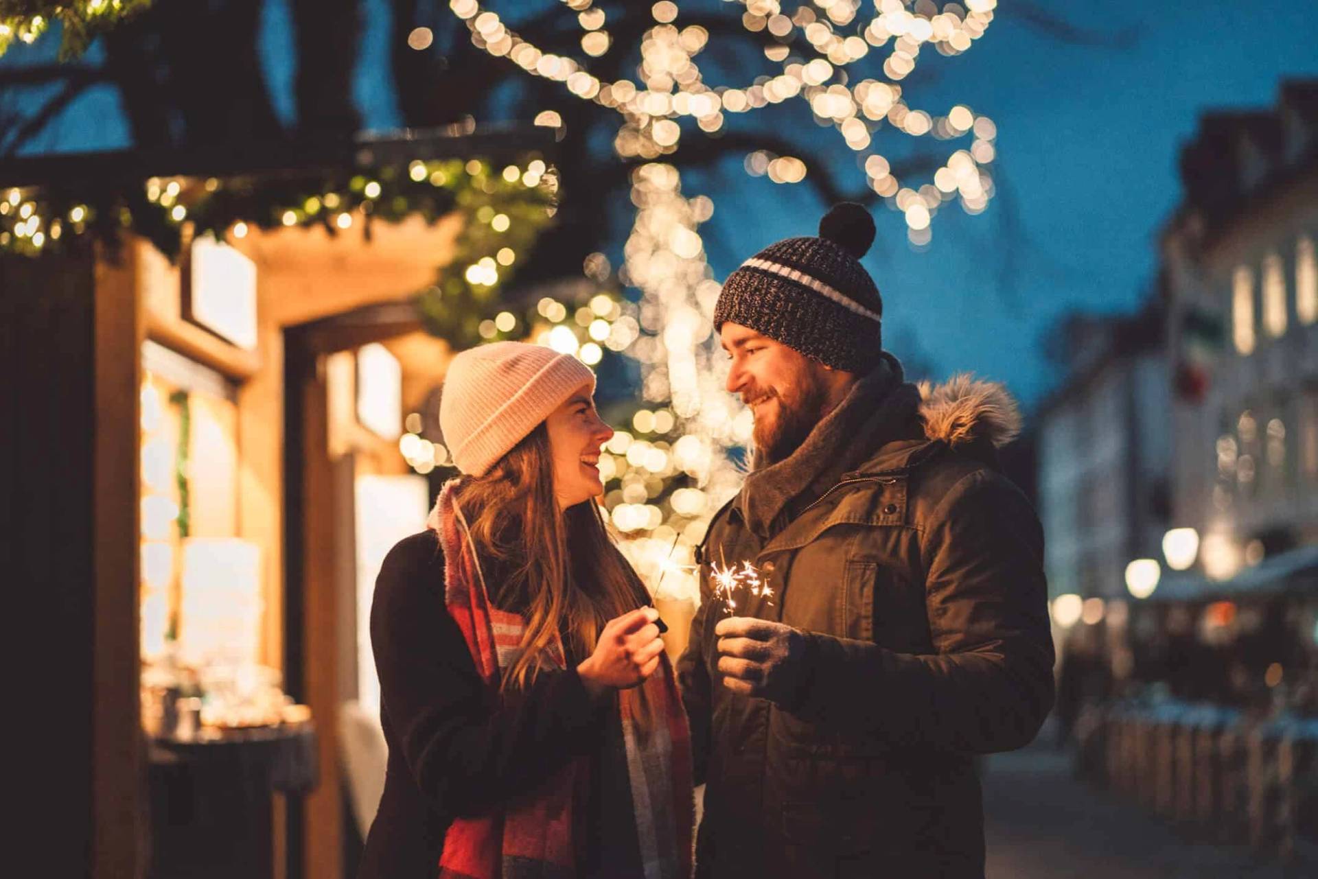 Deux personnes discutant sous des illuminations de fête.
