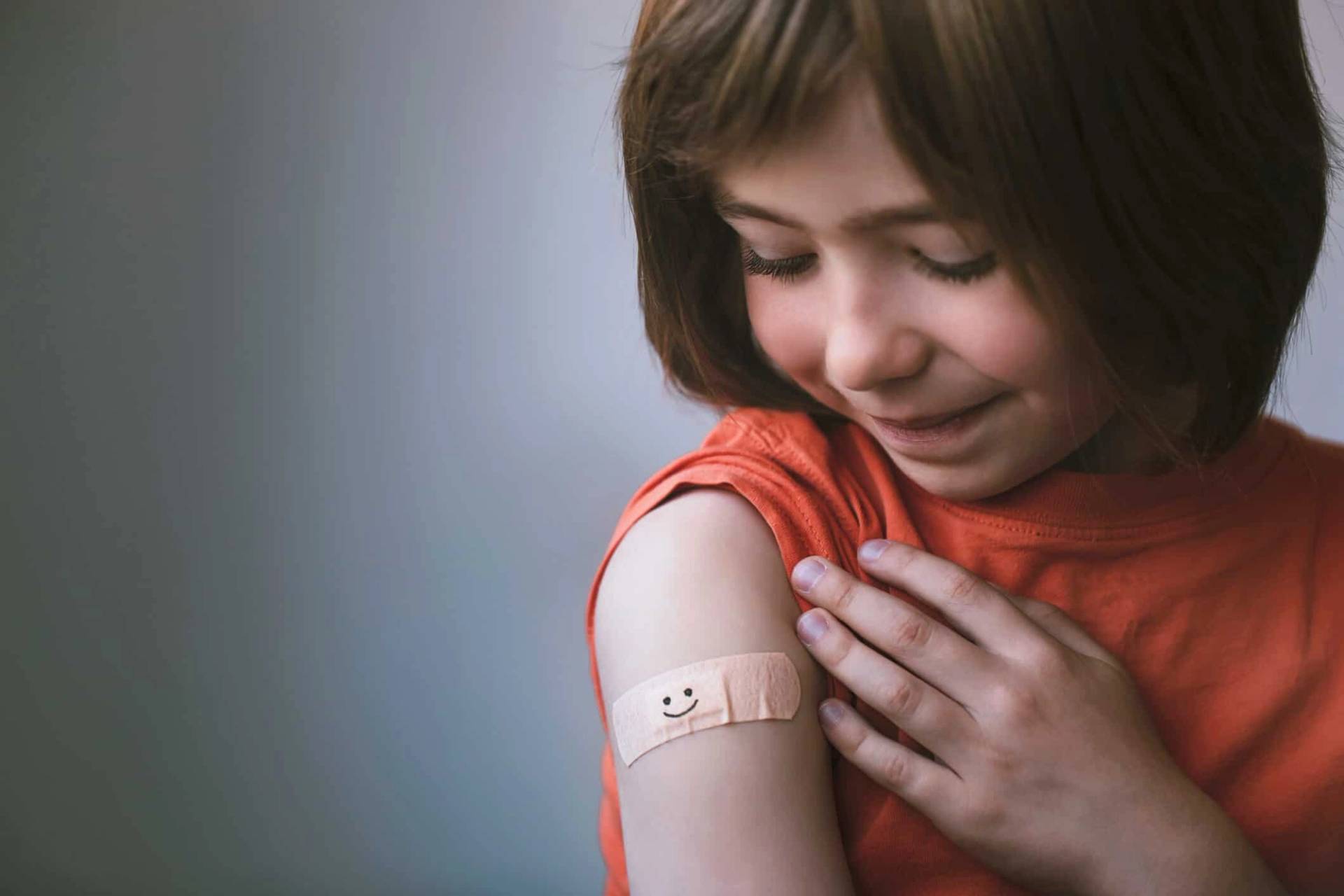 Enfant regardant un pansement sur son bras.