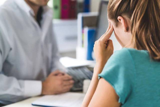 Patient consultée par un médecin pour une migraine, examen médical de céphalées