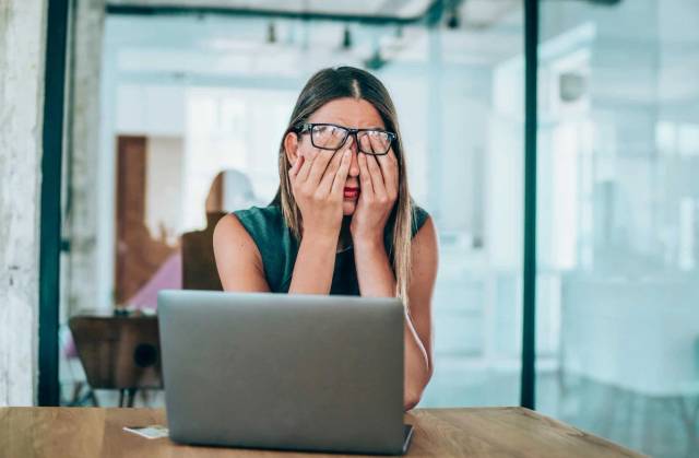 Femme stressée se tenant la tête, illustrant les symptômes physiques du stress