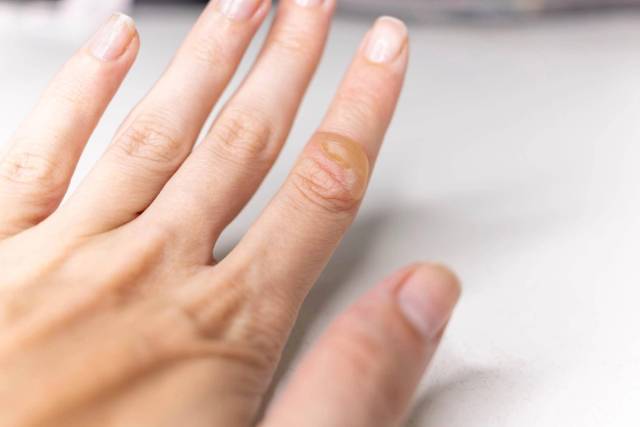 Main de femme avec les ongles visibles sur une table