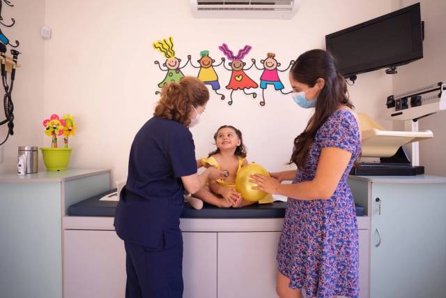 Un médecin examine un jeune enfant dans une clinique pédiatrique en présence d'un parent