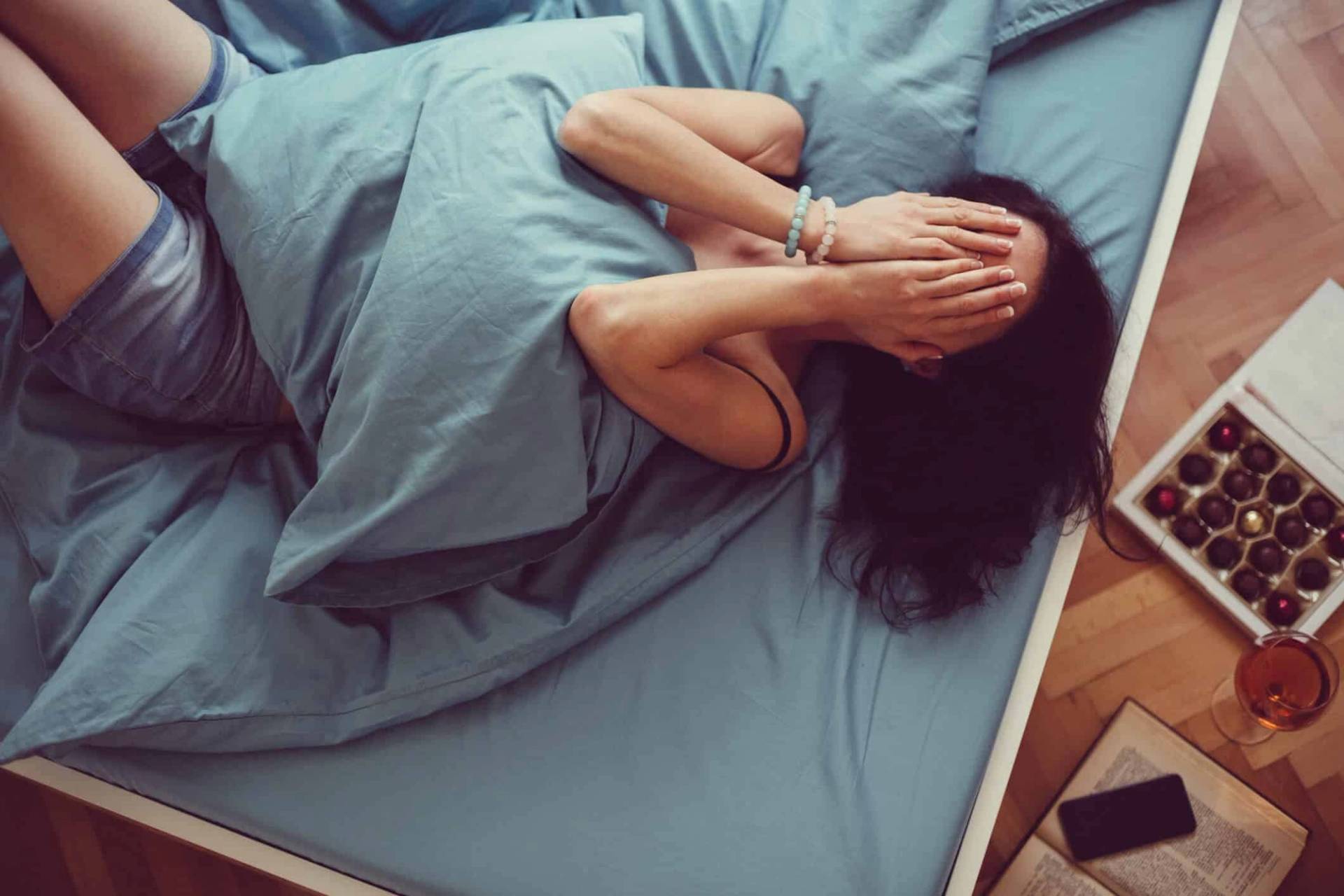 Femme ressentant une nausée avec la main sur l'estomac lors d'une consultation médicale