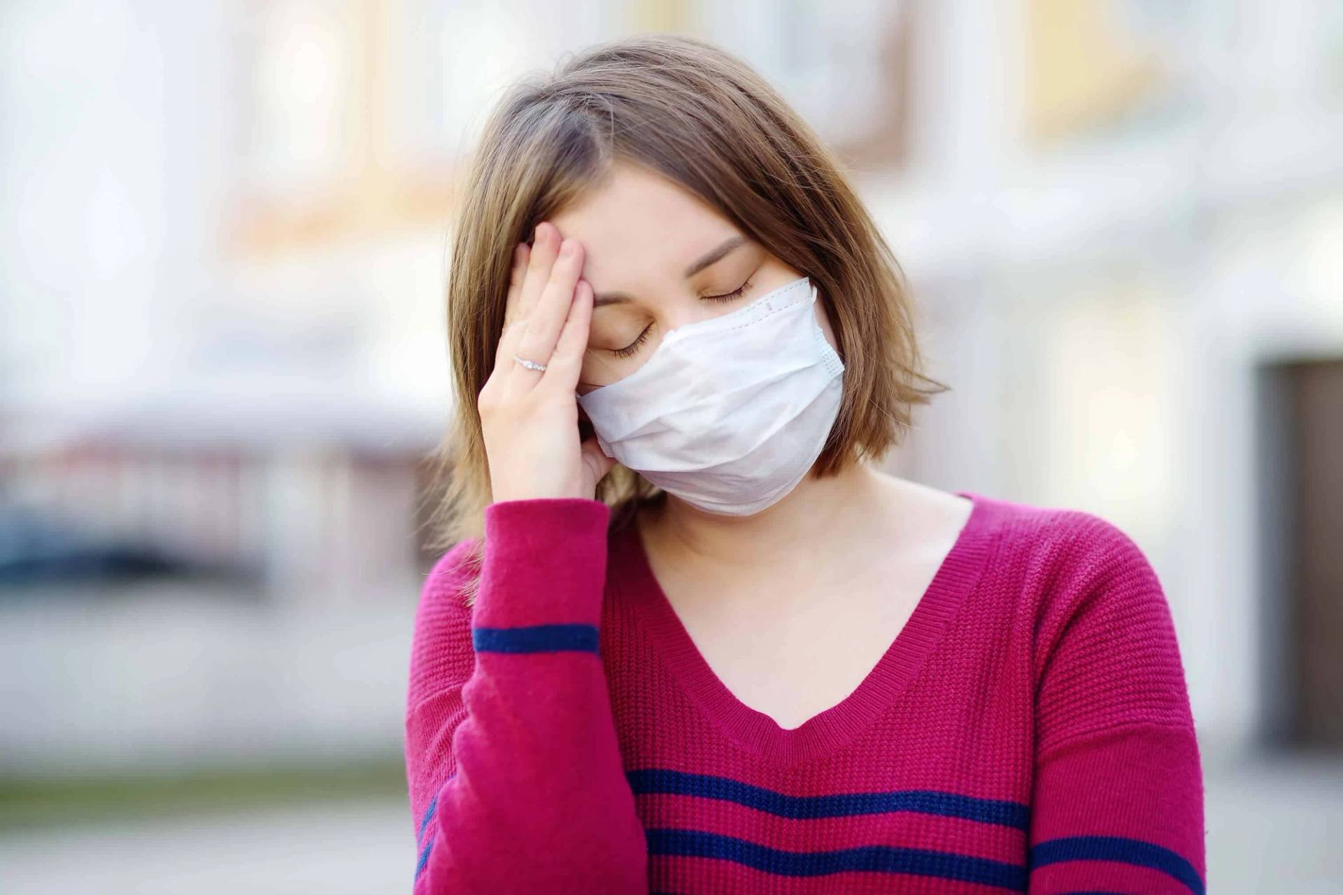 Femme souffrant de migraine due à la Covid-19 se tenant la tête lors d'une consultation médicale