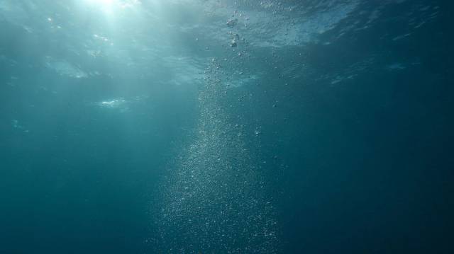 Scène sous-marine paisible avec de la lumière du soleil et des bulles s'écoulant dans l'océan